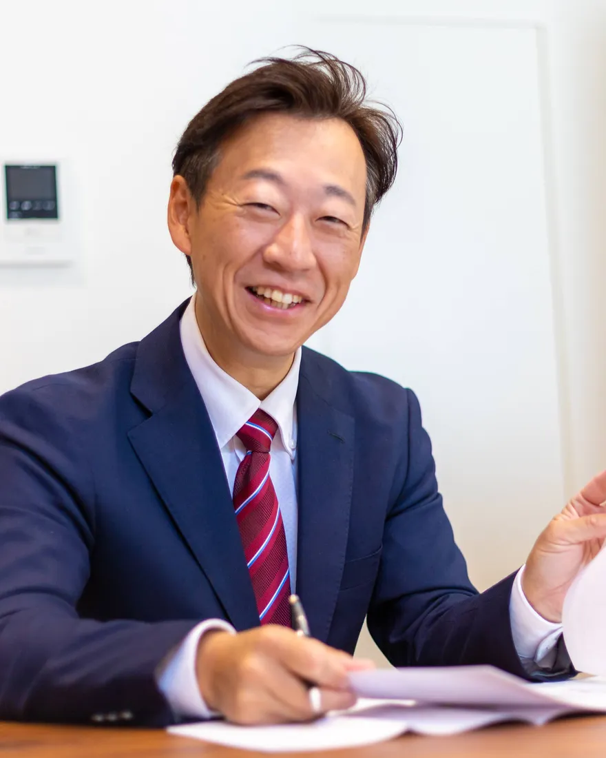 資料を手に笑顔でこちらを向く、森企画 代表 森 誠
